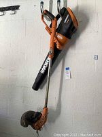 Full view of Worx 20V Max Lithium leaf blower and trimmer leaning against wall showing general condition and size.