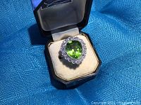 Ring displayed in box on blue fabric