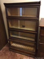 Front view of oak barrister bookcase showing four glass lift-up sections