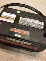 Top angled view of Motomaster car battery showing brand label and handle