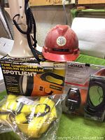 Various safety and utility items including harness, hard hat, boxed spotlight, and a multi-tool box
