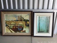 Photo showing two framed art pieces side by side: one riverboat bridge scene, one forest scene.