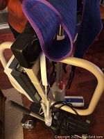 Close-up of the sling attached to the lift arm, showing the padded section and some control cables.