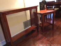 Photo showing both matching wooden tables positioned next to a wall and dining set, highlighting the longer side table and smaller end table.