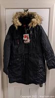 Front view of black women's insulated winter coat with fur-trimmed hood and Canada Weathergear tags attached