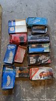 Overview photo of all 12 brake pad boxes with various brands and colors, showing new old stock packaging.