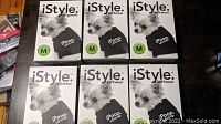 Six boxed black iStyle iPoopuScoop dog shirts, size Medium, laid out in two rows of three boxes each on a dark surface.