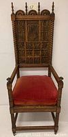 Full front view of carved oak chair with upholstered seat