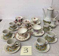 Full set of assorted collectible tea cups with saucers and Winterling coffee pot with creamer.
