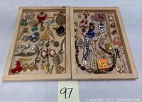 Overview of assorted costume jewelry displayed in two wooden trays