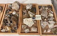 Image showing three wooden trays filled with various mineral rocks of different sizes, shapes, and colors, labeled '127'.