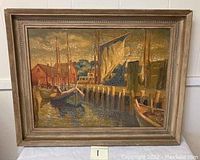 Full view of the framed harbor scene oil on board painting showing boats, docks, buildings, blue sky and signature.
