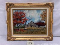 Full view of framed oil painting showing a rustic barn in an autumn landscape with colorful trees surrounding it