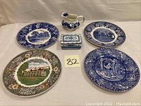 Full lot view showing four plates (three blue and white, one multicolored), a soap dish box, and a small pitcher.