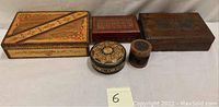 Lot overview showing five wooden vanity boxes and small items with painted and carved designs.