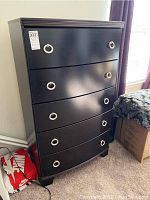 Front view of dark merlot colored five drawer chest showing silver ring handles on each drawer.