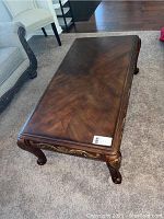 Angle view of coffee table showing overall shape, wood finish, and some background furniture context