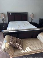 Front view of assembled sleigh bed frame with mattress in place showing headboard and footboard.