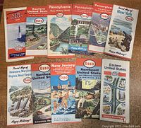 Photo showing 11 vintage road maps from ESSO in a fanned layout. Includes maps featuring New Jersey, Pennsylvania, New York, Delaware, Maryland, Virginia, West Virginia, Eastern United States and Northeast United States.