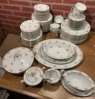 Complete set of Noritake floral china dinnerware and serveware displayed on table.