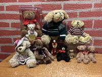 Lot of 10 teddy bears and stuffed animals displayed against brick background
