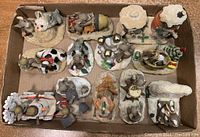 All 12 Charming Tails figurines arranged inside a box tray, showing various mice and winter snow scenes with yellowed snow.