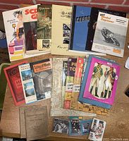 Top view showing the entire assortment of miscellaneous paper ephemera including manuals, booklets, and photo cards.