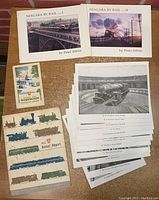 Collection of memorabilia items laid out on a surface including booklets, pamphlets, and black-and-white photographs