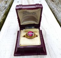Ring displayed in open vintage Art Deco style reddish-brown Bakelite case with padded cream interior.