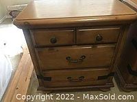 Front view of birch end table showing three drawers, wood grain and drawer hardware.