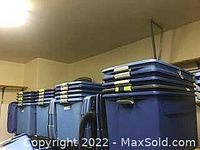 Multiple blue Sterilite 45-gallon plastic totes with lids stacked, showing rear wheels
