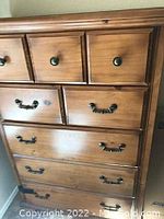 Front view of the birch 5-drawer bureau showing three smaller top drawers with round metal knobs and larger bottom drawers with metal pull handles.