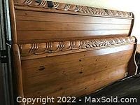 Birch wood king size headboard and footboard showing carved leaf detailing on top rails and natural wood finish.