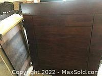 Photo showing the disassembled dark wood dining table top and legs.