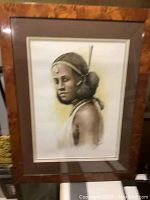 Full view of framed portrait showing woman in profile with braided hair and traditional jewelry, double matted in cream tones, warm brown wood frame.