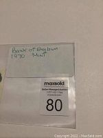 Protective sleeve with handwritten note 'Bank of England 1970 Mint' and auction label number 80.