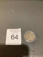 Photo of the coin's reverse side showing the Canadian coat of arms and the MaxSold Auction lot number beside it.