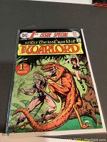 Front cover of comic showing colorful and detailed artwork of The Warlord fighting dinosaur-like creature, titled '1st Issue Special, The Warlord'