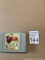Front view of the Nintendo 64 The Legend of Zelda: Ocarina of Time game cartridge with label visible, resting on a cardboard surface.