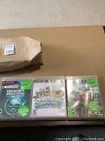 Three PS3 game cases (Ghost Recon Future Soldier, Skylanders Swap Force, Far Cry 3) laid out side by side on a surface with a brown envelope behind them.