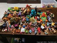 Wide view showing diverse Disney character figurines and toy vehicles arranged on table.
