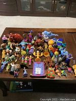 Full lot displayed on a table showing a variety of Disney character figurines and toys including animals and people from multiple Disney movies.