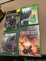 Four Xbox and Xbox One games in cases: Castlevania Curse of Darkness, Dying Light, Call of Duty Advanced Warfare, Crimson Skies High Road to Revenge.