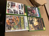 Photo showing four Xbox game cases including Far Cry 4, Ford Racing 3, Fuzion Frenzy Platinum Hits, Full Spectrum Warrior Limited Edition.