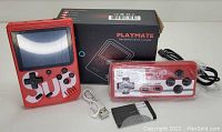 Red Play Mate handheld game console, red wired controller, USB charging cable, and packaging box.