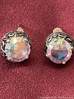 Front view of the pair of stud earrings showing faceted stones and black-accented silver design.