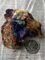 Rough mineral specimen with vivid blue azurite and green malachite on mineral matrix, next to a Canadian dime.
