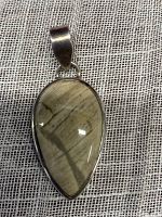 Full view of jasper pendant with teardrop shaped stone displaying natural beige and brown pattern, set in smooth silver bezel.