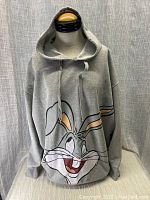 Front view of gray hoodie with large Bugs Bunny smiling head graphic, on a mannequin.