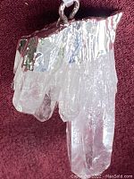 Close up of the clear quartz cluster pendant showing the silver-tone metal setting at the top of the natural crystal points.